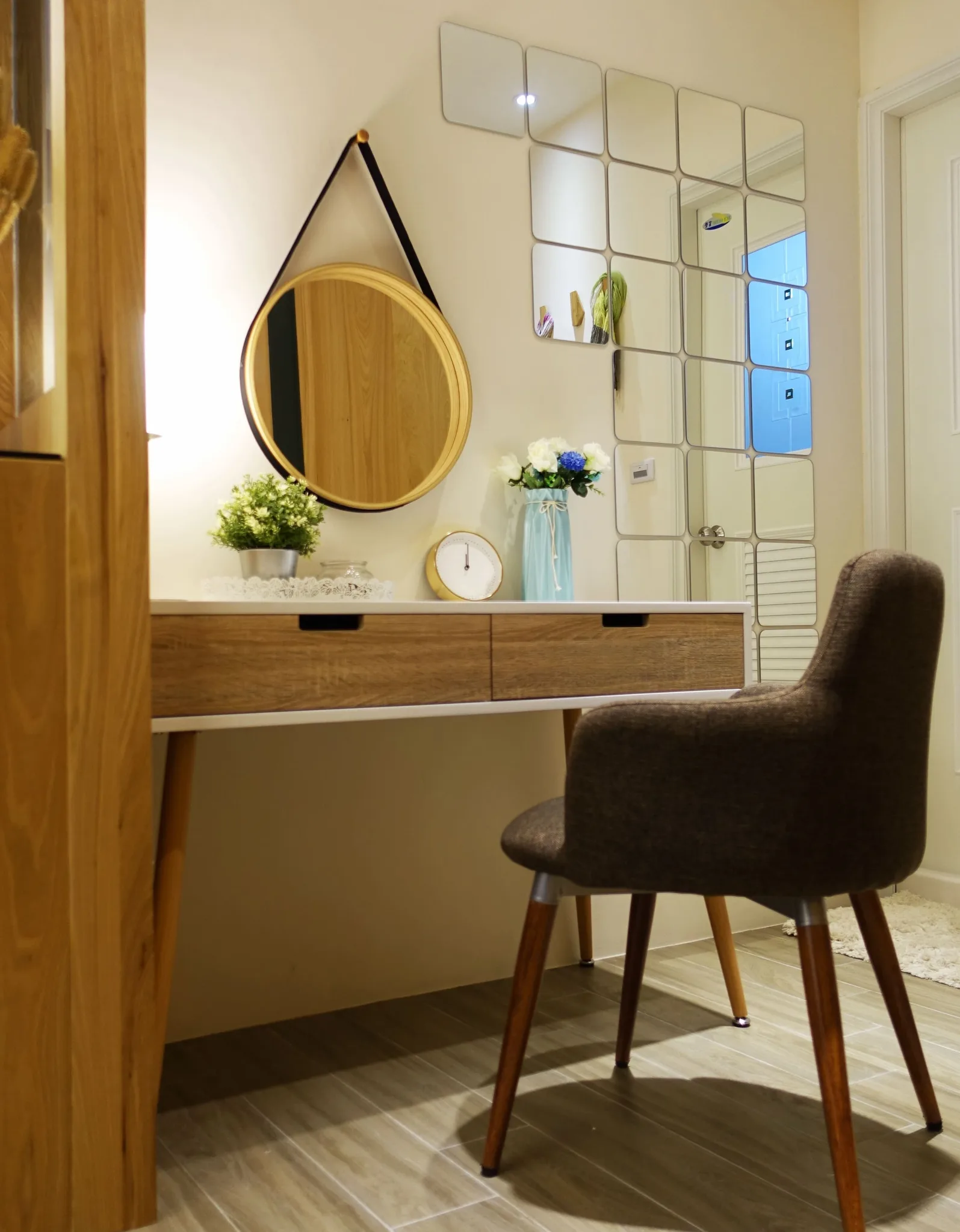 住宅臥室梳妝區，木質梳妝台搭配圓形掛鏡與方格裝飾鏡